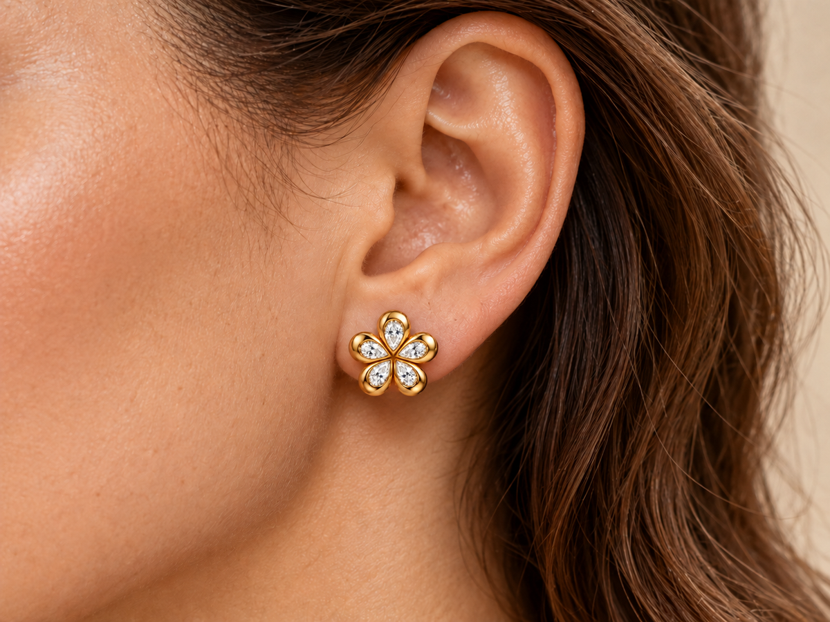 14k yellow gold diamond flower stud earring shown on an ear